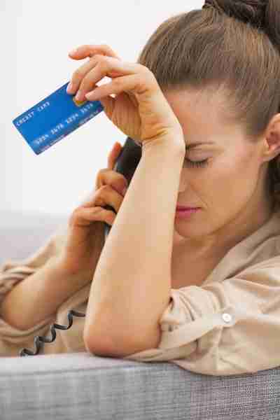 Upset woman holding a credit card.